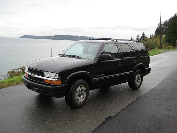 Black Chevrolet Blazer SUV parked on a road by the water