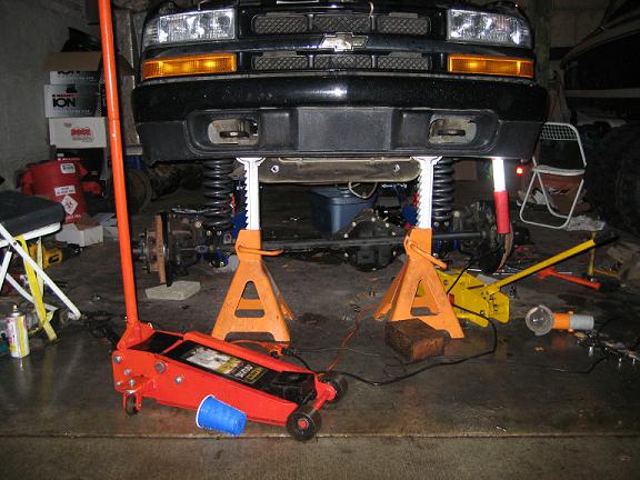 Front of a black 2004 Chevrolet Blazer on jack stands, undergoing repairs