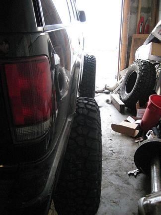 2004 Chevrolet Blazer - Rear view of a modified 2004 Chevrolet Blazer showing a large off-road tire and fender clearance.