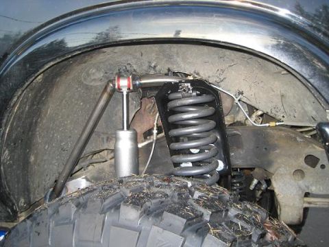 2004 Chevrolet Blazer - Close-up view of the suspension system, a large coil spring and shock absorber.