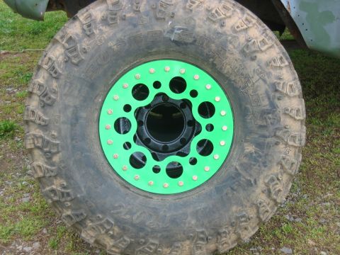 1992 Ford Mustang - Close-up of a off-road tire a vibrant green beadlock ring and prominent tread pattern.