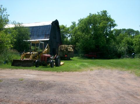 2000 Chevrolet Tahoe - Farm scene with a tractor, barn, hay bales, and a red SUV in the distance.