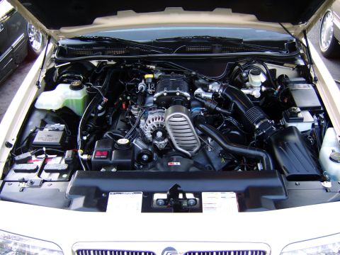 1996 Mercury Grand Marquis - The engine bay of a car is shown, a prominent supercharger and intricate mechanical components.