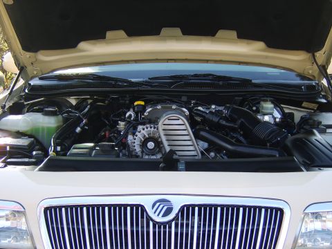 1996 Mercury Grand Marquis - The engine bay of a 1996 Mercury Grand Marquis is shown with the hood open.