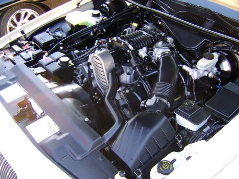 1996 Mercury Grand Marquis - The engine bay of a vehicle, a supercharged engine and various fluid reservoirs.