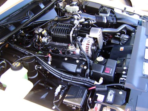 1996 Mercury Grand Marquis - Engine bay view showing a supercharger, alternator, and various hoses and components.