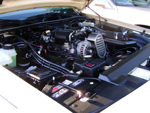 1996 Mercury Grand Marquis - The engine bay of a 1996 Mercury Grand Marquis is visible, with various components including the supercharger and battery clearly depicted.