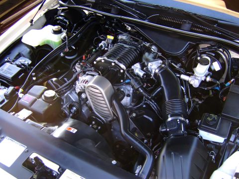 1996 Mercury Grand Marquis - Close-up view of a modified engine bay a prominent supercharger unit.