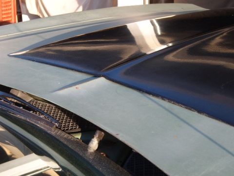 1973 Ford Ranchero - Close-up of a car's hood, showing a black scoop and windshield wipers.