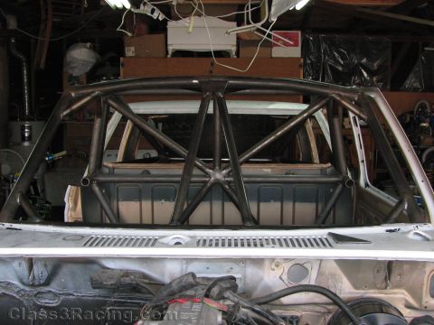 1990 Ford Bronco - Photo of a fabricated roll cage inside a vehicle shell in a workshop, not a technical document.