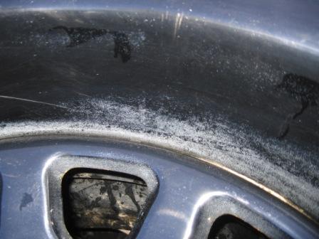 1993 Ford Bronco - Close-up of a faded blue painted body panel with surface oxidation next to a black trim piece, detailing wear.