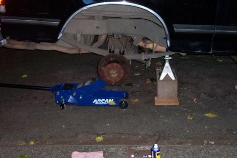 1989 Ford Bronco - Vehicle is raised on a jack and jack stand for maintenance on the rear axle and suspension.