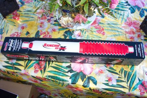 1989 Ford Bronco - A box containing a Rancho RS9000 shock absorber is displayed on a floral tablecloth.