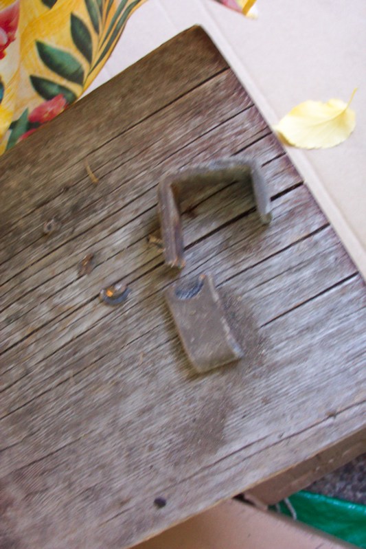 Old metal hardware piece resting on a weathered wooden board