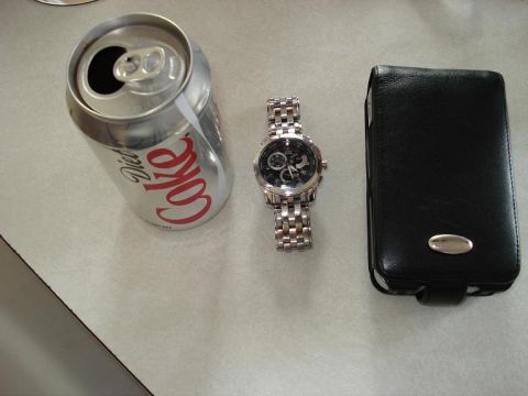2000 Ford Crown Victoria - A Diet Coke can, a silver watch, and a black leather phone case are arranged on a textured surface.