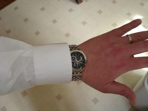 2000 Ford Crown Victoria - A person's left arm wearing a white dress shirt cuff and a silver watch is positioned over a patterned surface. A ring is visible on the pe…