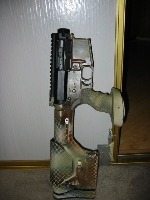 1996 Ford Bronco - The image shows a close-up of a firearm with camouflage paint. The firearm is resting against a wall and on a carpeted floor.