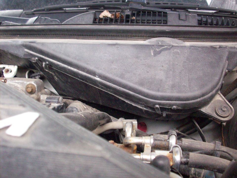 Engine bay close-up showing cowl panel, firewall lines and fittings on a Grand Marquis