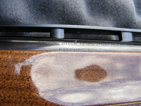 1979 Ford Bronco - The image shows a close-up view of engraved text on a metallic surface, likely a firearm barrel, with a wooden surface in the foreground. T…