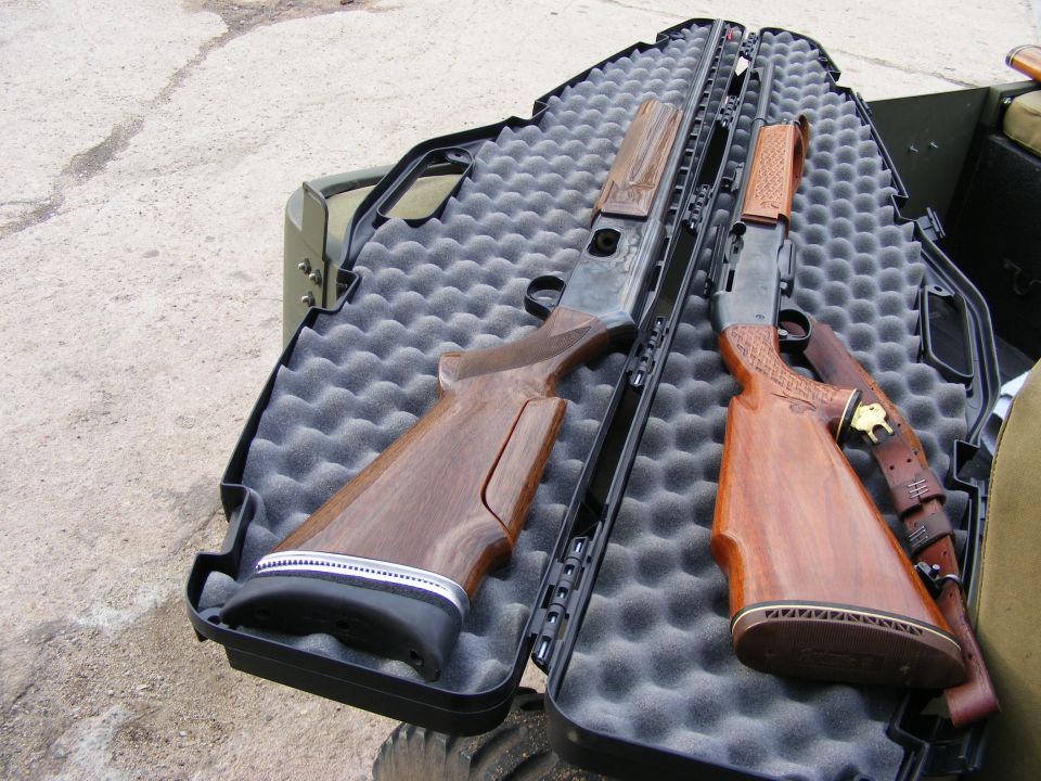 Two shotguns in a black gun case with foam padding.