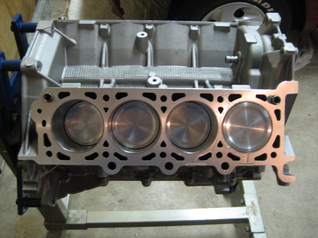 Photo of a four-cylinder bank of an engine block with pistons installed