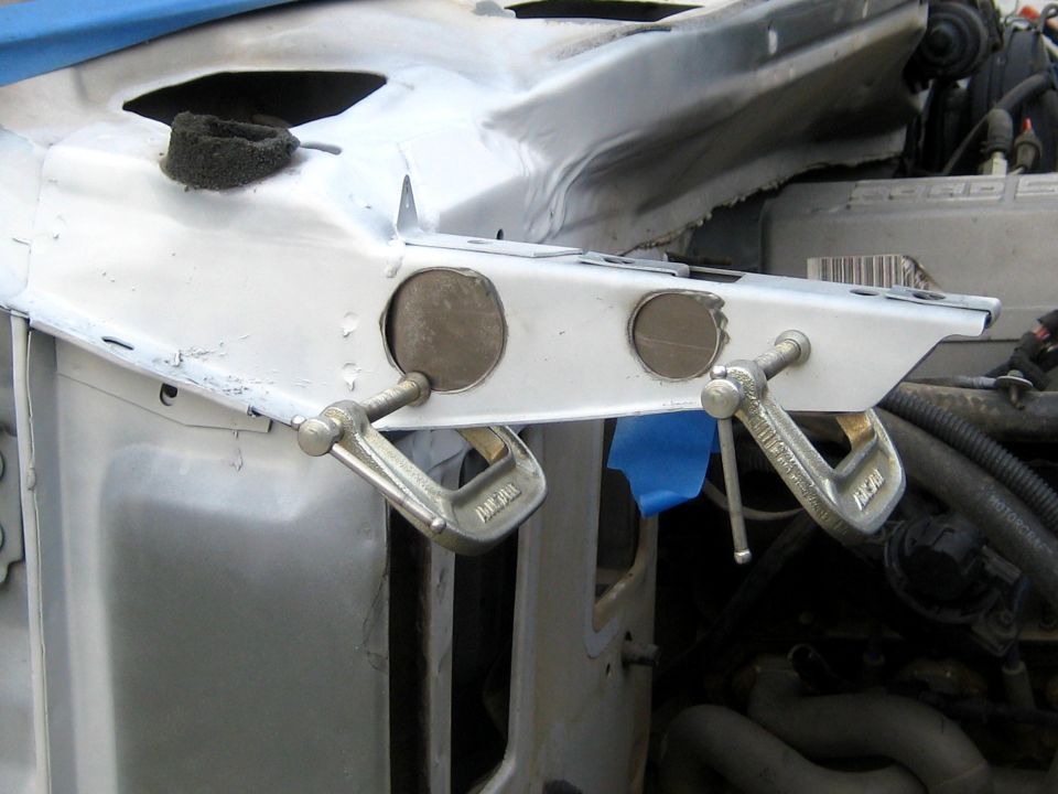 Steel reinforcement plate clamped to inner fender rail with rosette holes ready to weld