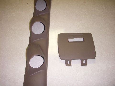 1993 Ford Bronco - A brown A-pillar gauge pod with three circular openings and a brown dash panel cover with a rectangular cutout are shown on a textured surf…