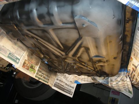 1992 Ford Crown Victoria - The underside of a vehicle, possibly a Ford Crown Victoria, is shown with a protective layer of newspaper taped around the edges. The under…