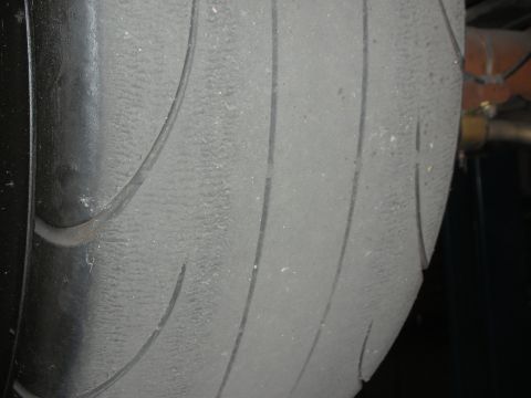 1992 Ford Crown Victoria - A close-up, side view of a worn tire tread on a vehicle. The tire shows significant wear and has visible tread lines.