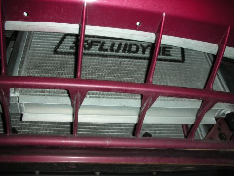 1992 Ford Crown Victoria - A close-up view of the front of a vehicle, showing a large aftermarket radiator with the "FLUIDYNE" logo visible. The radiator is partially…