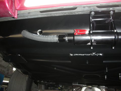 1992 Ford Crown Victoria - Close-up of a modified fuel system component mounted to the underside of a vehicle.