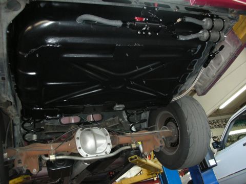 1992 Ford Crown Victoria - The underside of a vehicle is visible, with a focus on the fuel tank and rear axle assembly.
