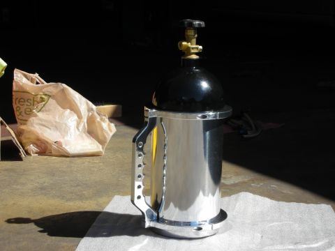 1992 Ford Crown Victoria - A nitrous oxide bottle with a polished metal body and black top sits on a white surface.