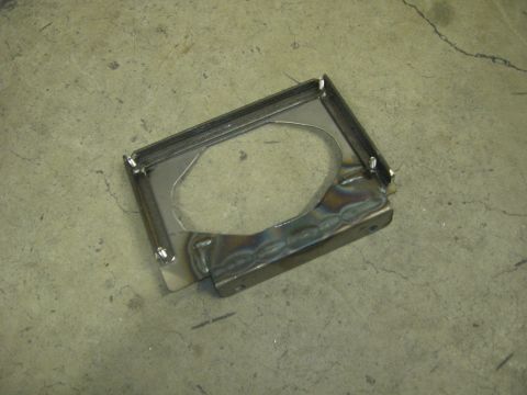 1996 Ford Bronco - A fabricated metal bracket with a circular cutout sits on a concrete surface.