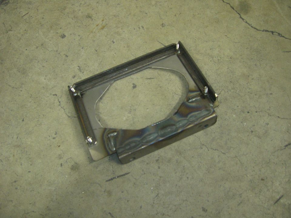 Metal bracket with welded seams and bolt holes on concrete floor