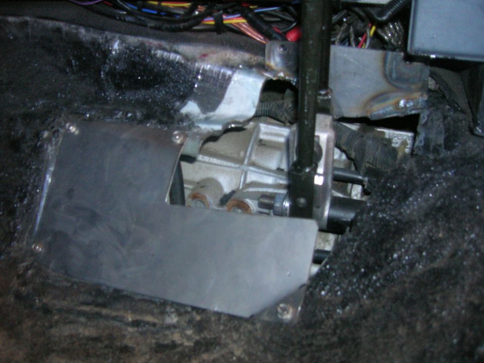 Close-up of manual transmission shifter linkage and surrounding floor pan area