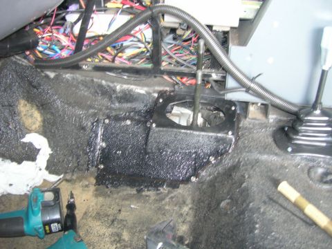 1996 Ford Bronco - Interior view of a vehicle's transmission tunnel and wiring harness, with tools present.