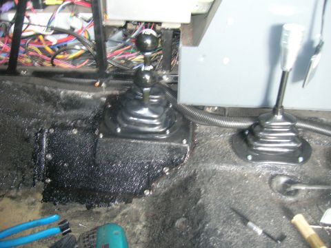 1996 Ford Bronco - The floor of a vehicle shows two gear shifters and exposed wiring, suggesting a custom or modified setup.