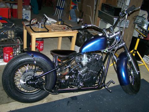 1988 Suzuki Samurai - A custom blue motorcycle with a bobbed rear fender and ape hanger handlebars sits in a garage.