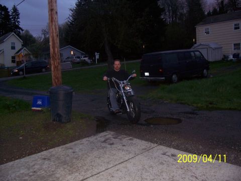 1988 Suzuki Samurai - Man rides a custom motorcycle on a driveway with a black van in the background.