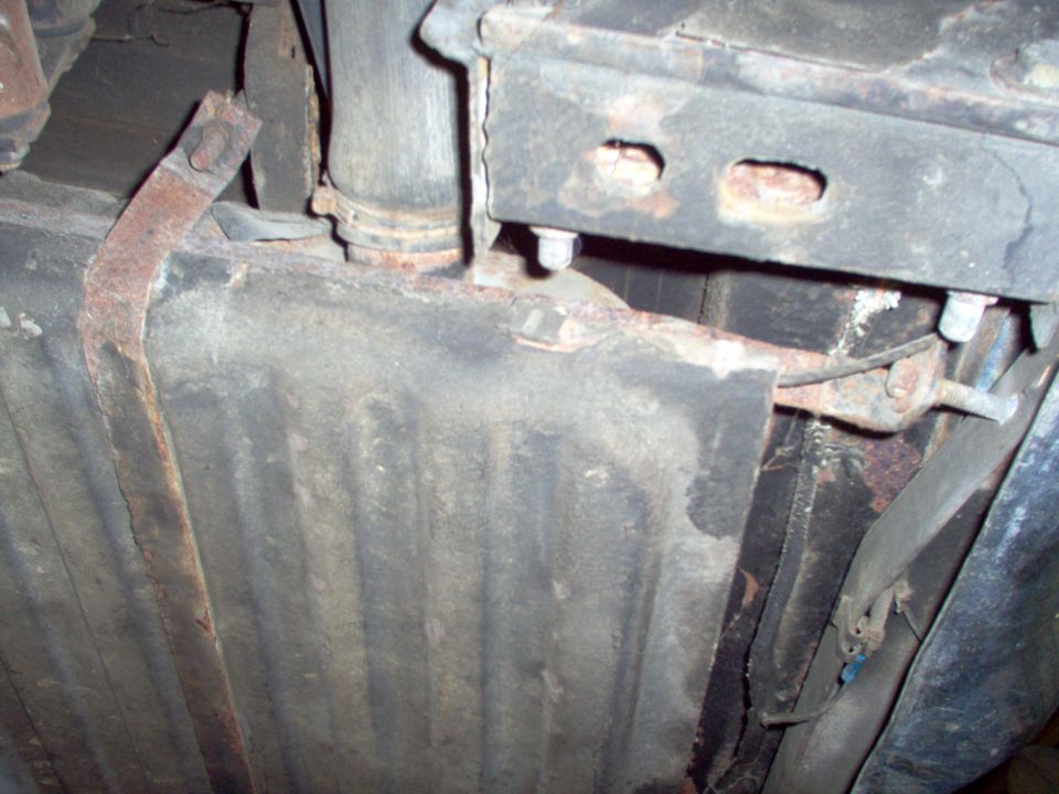 underside of car showing fuel tank, exhaust pipe, and frame components