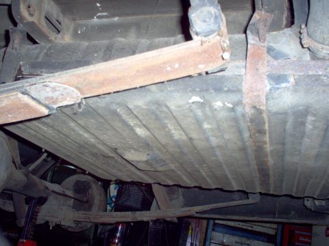 1970 Ford Ranchero - The underside of a vehicle, focusing on the suspension and fuel tank, with visible rust and wear.