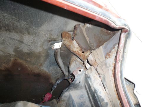 1975 Ford Ranchero - Close-up view of a heavily rusted wheel well interior, showing structural damage and exposed wiring.