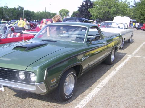 1970 Ford Ranchero - A green 1970 Ford Ranchero is parked at an outdoor event, with other vehicles visible in the background.