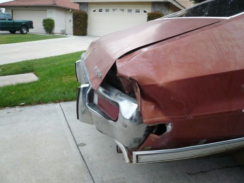 1975 Ford Ranchero - Rear view of a damaged 1975 Ford Ranchero, showing significant damage to the quarter panel and bumper.