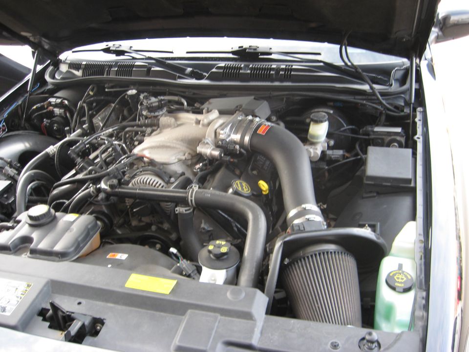 Engine bay with aftermarket air intake. Looks like a Ford Crown Victoria