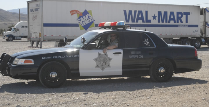 Black and white police car, 1991 Ford Crown Victoria LTD, side view, with "Keeping the Peace Since 1850" text and sheriff's star