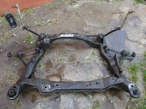 1995 Ford Taurus - Front subframe assembly with suspension components, likely from a car, is shown on the ground.