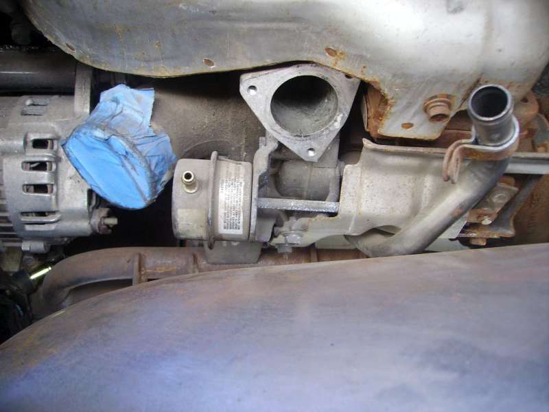 Turbocharger in engine bay with open compressor outlet flange and wastegate actuator