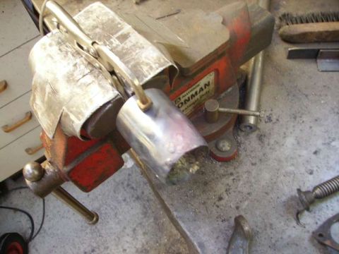 1969 MINI Cooper - Metal exhaust pipes are held in a vise, suggesting repair or modification work.